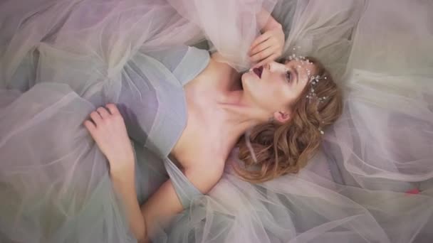 漂亮的年轻迷人的职业女性模特 头戴发冠 穿着华丽的仙女公主花边裙躺在地板上 — 图库视频影像