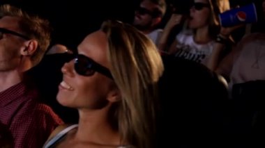 Bir grup mutlu, genç ve çekici bayan arkadaş patlamış mısır yiyor. 3D aksiyon sinemasının tadını çıkarıyorlar.