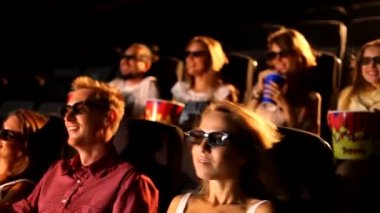 Bir grup heyecanlı, genç, çekici, mutlu kadın arkadaş 3D aksiyon filmi sinemasında patlamış mısır yiyor.
