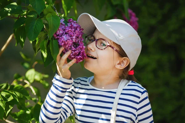 Bahçede Lila Çiçek Kokulu Kız Çocuk Seçici Odak — Stok fotoğraf