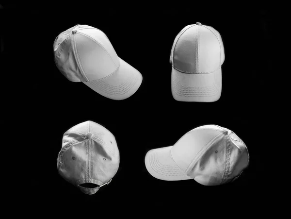 Blank white baseball caps on black background.