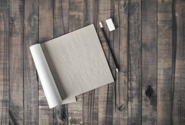 Açık kare biçimi broşür veya Not defteri, kalem ve silgi ahşap masa arka plan üzerinde. Düz yatıyordu.