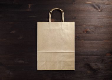 Ahşap arka plan üzerinde boş craft kağıt torba. Duyarlı tasarım mockup. Düz yatıyordu.
