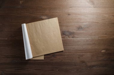 Kraft kağıt ahşap arka plan üzerinde boş not defteri. Mockup tasarımınız için. Düz yatıyordu.