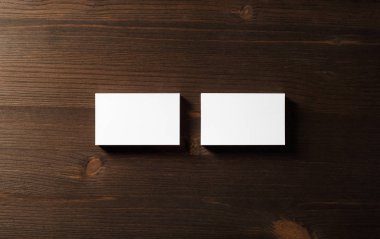 İki yatay kartvizit ahşap masa arka plan üzerinde boş. Düz yatıyordu.