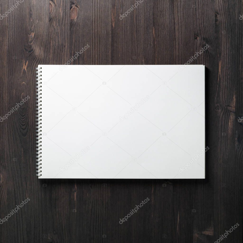 Blank spiral notebook on wood table background. Space for text. Flat lay.