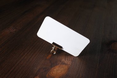 Ahşap masa arkasında boş bir kartvizit. Marka kimliği için modelleme.