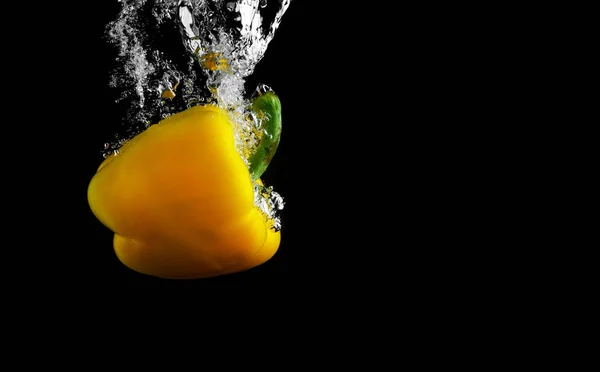 Gelber Paprika Fällt Ins Wasser Mit Spritzer Auf Schwarzem Hintergrund — Stockfoto
