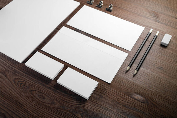 Blank corporate identity template on wood table background. Photo of blank stationery set. Mockup for design presentations and portfolios.