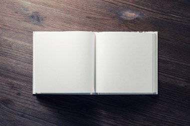 Ahşap arka plan üzerinde boş kitap kadar sahte. Düz yatıyordu.