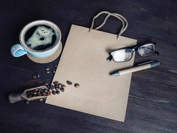 Натюрморт Чашкой Кофе Кофейными Зёрнами Стаканами Ручкой Бумажным Пакетом Крафта — стоковое фото