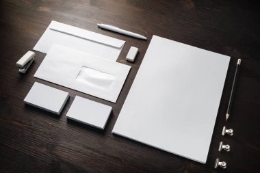 Ahşap masa arka planında boş şirket kırtasiyesi. Marka kimlik modeli.