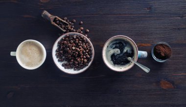 Eski bir kahve fonu. Espresso, kahve fincanı, kavrulmuş kahve çekirdekleri ve ahşap arka planda öğütülmüş toz. Düz yatıyordu.