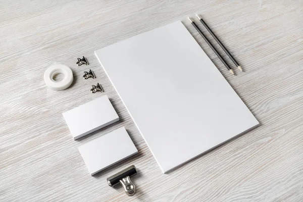 Photo of blank corporate identity. Stationery set. Branding mockup. Sheets of paper, letterhead, business cards, scotch tape and pencils.