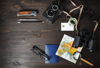 Yolculuk için hazır. Seyahat planı geçmişi. Eski ahşap arka planda gezgin aksesuarları ve eşyalar. Düz yatıyordu.