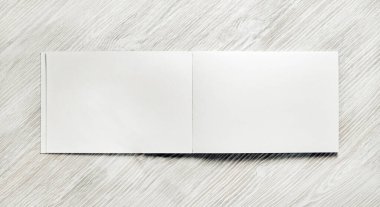 Açılmış boş not defteri açık tahta masa arka planında. Tepkili tasarım şablonu. Düz yatıyordu.