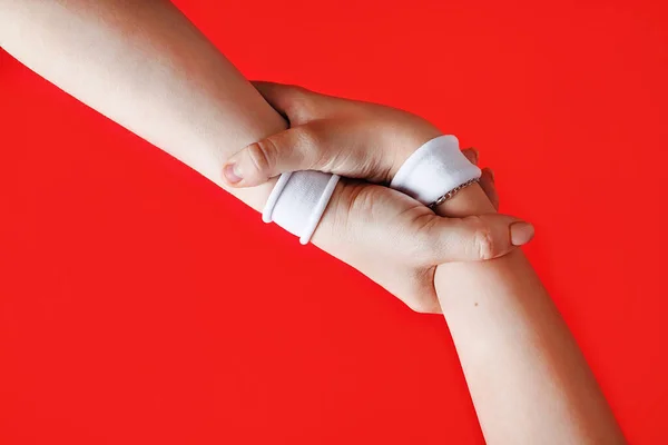 Handen Helpen Concept Handen Met Witte Armbanden Rode Achtergrond — Stockfoto