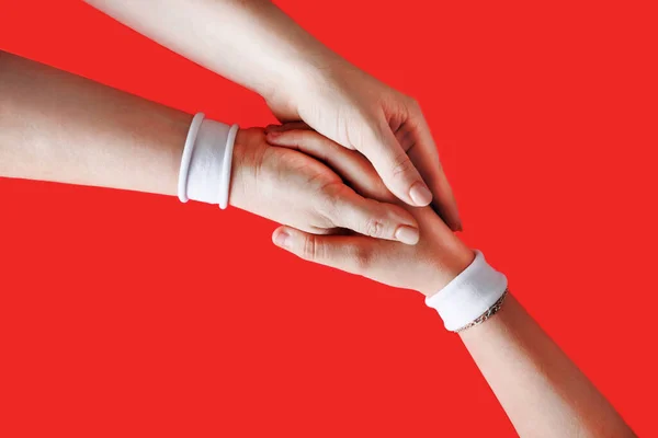 Hände Mit Weißen Armbändern Vereinigen Sich Als Freundschaftsgruß Auf Rotem — Stockfoto