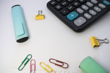 Ofis malzemeleri beyaz bir masada, üst manzara. Ofis ve okul kavramı