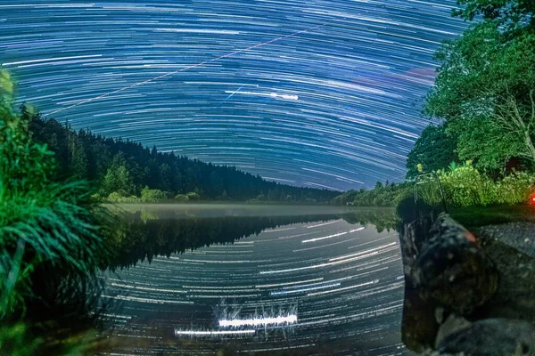 Larga exposición Startrails sobre un lago idílico con reflejos estelares en el agua maravillosa estrella noche clara. — Foto de Stock