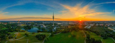 Münih, Bavyera. 2020 yazında kulesi ve stadyumuyla popüler Olimpiyat Parkı 'nın üzerinde etkileyici bir gün doğumu.
