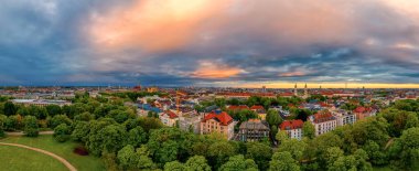 Bavyera 'daki Münih manzarası, bir parkın üzerindeki panoramik bir anten, evler ve Bavyera başkentinin tarihi merkezindeki frauenkirche..