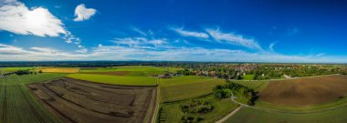 Berrak dağ arazileri ve ufukta Alpler olan huzurlu yaz manzarası