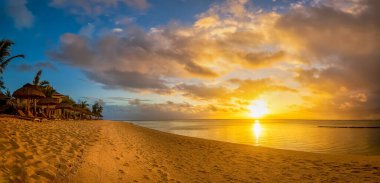 Mauritius 'ta güzel bir gün batımı, Le Morne' de okyanus kıyısında palmiyeleri olan bir plajda..