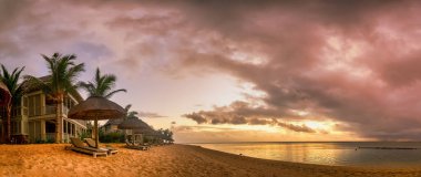 Mauritius 'ta güzel bir gün batımı, Le Morne' de okyanus kıyısında palmiyeleri olan bir plajda..