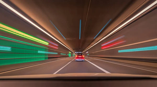 Fast driving car through a tunnel with blurry light effects, a urban race scene with leading lines and symmetry.