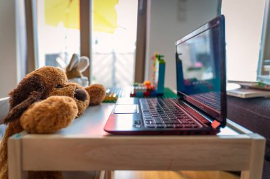 Oyuncak ayıyla arkadaşı laptopta çalışan bir tavşanın olduğu komik bir ev sahnesi..
