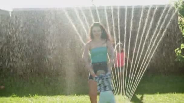 家庭玩草坪水洒在母亲与孩子 — 图库视频影像