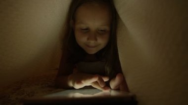 Çocuk Tablet ile oynarken battaniyenin altında