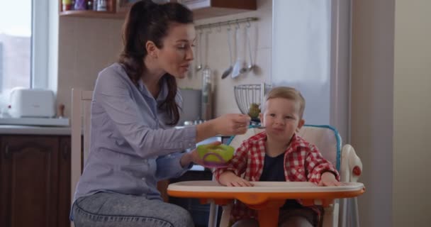 Kind Sitzt Kinderstuhl Und Isst Mit Mutter Essen — Stockvideo