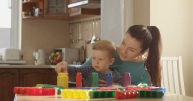 Mother Teaching Little Boy How to Count Using Colored Blocks and Using Educational Games