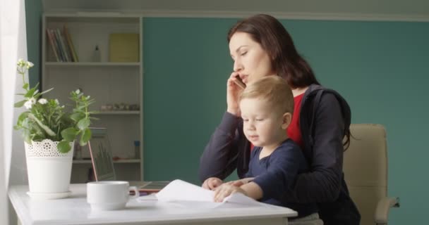 Успішна Мати Працює Домашнього Офісу Маленьким Сином Столом Паперами Документами — стокове відео