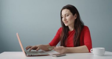 Genç kadın yapma Online alışveriş Holding kredi kartı defter tepki mutlu başarılı satış işlem shot kırmızı kamera önünde