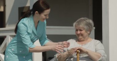 Kıdemli Kadın Pills Hemşire Alarak Portresi Kırmızı Kamera Sunny Day Shot Hemşirelik Evi Açık Havada Birlikte Gülümseyen Tıp veriyor