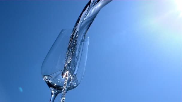 Water Stroomt Naar Een Glas Met Blauwe Lucht Zonneschijn Achtergrond — Stockvideo