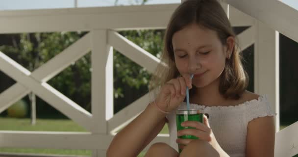 裏庭でリフレッシュメントドリンクでくつろげる美しい十代の少女 — ストック動画