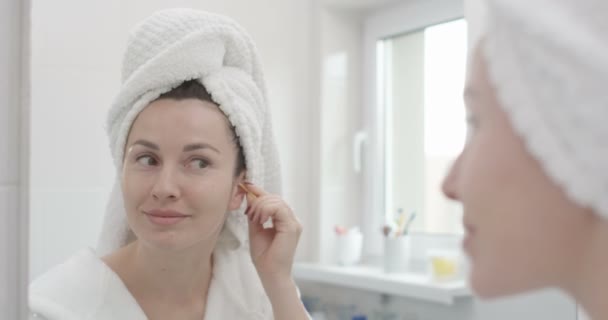 女性是清洁耳朵与棉拭子在浴室拍摄红色史诗 — 图库视频影像
