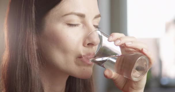 赤いカメラでクローズアップされた太陽とガラスの屋内から水を飲む喉の渇き女性 — ストック動画