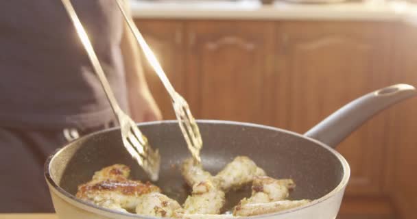 Uomo Cucina Pollo Ali Una Padella Cucina Con Sole Splendente — Video Stock