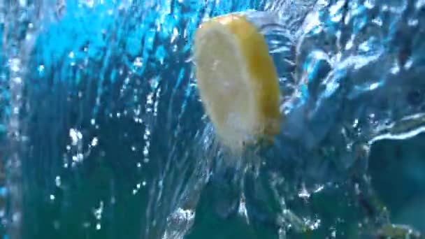 Zitronenscheibe Fliegt Zeitlupe Durch Wasserkaskade — Stockvideo