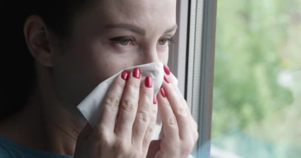 Mujer Estornudando Una Servilleta Pie Junto Ventana — Vídeos de Stock