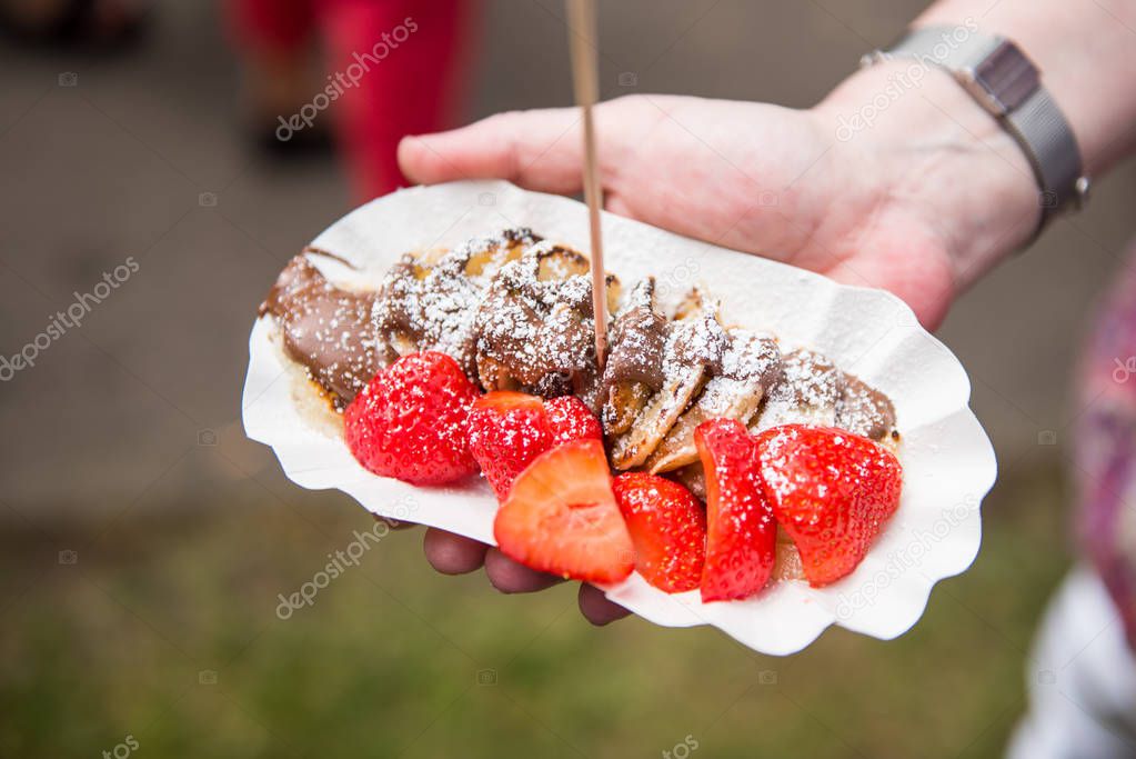 Street Food - pancakes and a bowl of strawberries in hand