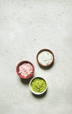 Sandviç, tost ya da crostini için tarama, tzatziki ve guacamole soslu kase. Gri arka planda vejetaryen aperatifi