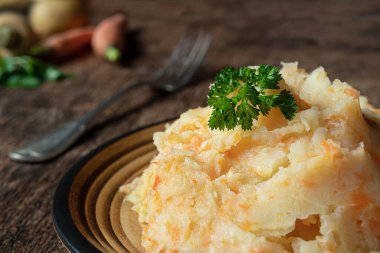 Koyu ahşap arka planda patates ve havuç ezilmiş havuç. Vitamin ve mineral açısından zengin lezzetli ve sağlıklı vejetaryen püresi.