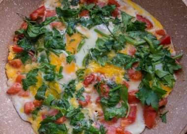 Domatesli omlet ve tavada maydanoz.