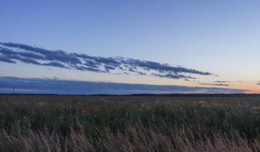Kırsal kesimde gün batımı, Moskova bölgesi, Rusya. Mavi bulutlar, orangutan